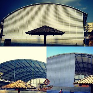 Veneziana industrial translúcida instalada em fachada de galpão, permitindo ventilação e iluminação natural no ambiente industrial.