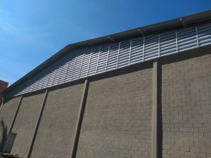 Venezianas industriais em PVC instaladas em galpão no Rio de Janeiro, proporcionando ventilação e iluminação natural ao ambiente industrial.