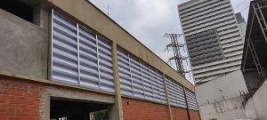 Veneziana Industrial Fechamento instalada em galpão, promovendo ventilação constante, proteção térmica e fechamento funcional com design robusto.
