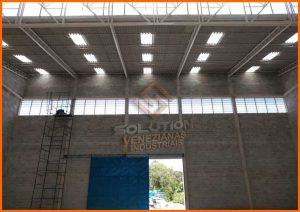 Veneziana Industrial Transforme Seu Espaço Veneziana Industrial Transforme Seu Espaço, aplicada em fachada de galpão, proporcionando ventilação contínua, entrada de luz natural e design funcional com alta durabilidade