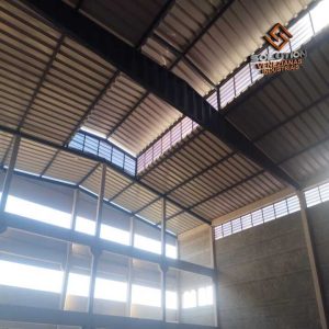 Janelas Industriais Lanternim instaladas em galpão industrial, proporcionando ventilação natural, iluminação e benefícios estruturais de alta eficiência