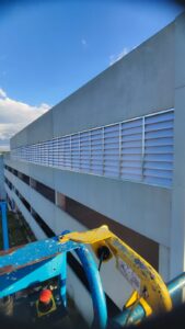 Foco na estrutura de fixação e requadro das venezianas Solution na OPUSPAC, fabricados em aço galvanizado a fogo. A imagem ressalta a robustez da engenharia e a resistência do material contra corrosão.