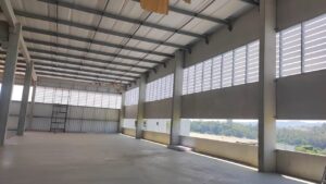 Vista lateral mostrando o alinhamento das venezianas Solution na OPUSPAC. As linhas horizontais das aletas seguem um padrão rigoroso de instalação, garantindo estanqueidade e harmonia visual com o galpão.