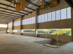 Detalhe do encontro da veneziana industrial Solution com o beiral do telhado na OPUSPAC. A imagem mostra os rufos e arremates que garantem a vedação total contra infiltrações de água.