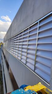 Interior da fábrica OPUSPAC iluminado naturalmente pelas venezianas Solution. A imagem mostra as máquinas e postos de trabalho claros, sem a necessidade de lâmpadas acesas durante o dia.