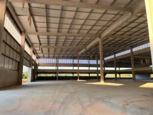 Vista de dentro da fábrica da OPUSPAC, mostrando o ambiente de trabalho iluminado naturalmente pelas venezianas Solution. A luz branca e suave preenche o espaço, destacando o conforto térmico proporcionado pela ventilação permanente.