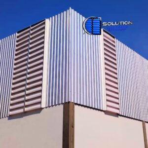 Utilizando aletas de Policarbonato, o sistema Solution garante a estanqueidade total através de arremates e rufos de vedação precisos, impedindo infiltrações. Tecnicamente, essa disposição favorece a ventilação cruzada, uma vez que as aberturas podem ser distribuídas ao longo de toda a envolvente do galpão, garantindo que o volume de ar interno seja renovado de forma homogênea, reduzindo a temperatura por convecção natural.Destaques Técnicos:Compatibilidade: Adaptável a perfis trapezoidais (LR32, LR40, LR100) e ondulados.Vantagem: Dispensa grandes reforços estruturais em comparação a janelas convencionais.Performance: Combinação de ventilação permanente com ganho de iluminação lateral difusa.