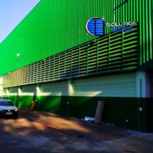 As venezianas Solution com acabamento em pintura eletrostática a pó (poliéster/epóxi) garantem proteção anticorrosiva superior para estruturas de aço. O processo de cura em estufa assegura uma superfície homogênea e resistente ao desbotamento provocado pela exposição solar. Esta solução é ideal para projetos que exigem ventilação passiva de alta vazão e manutenção da padronização estética corporativa, unindo robustez mecânica à personalização arquitetônica.