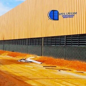 Além do apelo estético, o acabamento preto fosco é tecnicamente eficiente em fachadas onde se deseja minimizar o brilho solar externo. Quando combinadas com estruturas de aço ou concreto aparente, estas venezianas criam um contraste elegante, elevando o valor imobiliário do empreendimento. O sistema mantém as taxas de vazão de ar exigidas pelas normas de conforto térmico, provando que é possível unir alta performance técnica a um design de exceção.