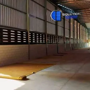 Fachada industrial com venezianas Solution em aço galvanizado e pintura eletrostática preto fosco, destacando o design moderno e as lâminas para ventilação permanente.