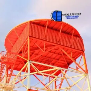 Fachada industrial com venezianas Solution em aço com pintura eletrostática laranja, destacando o acabamento vibrante e a ventilação permanente