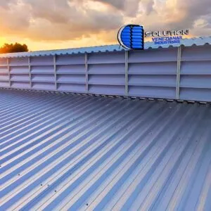 Lanternim de galpão equipado com venezianas Solution em policarbonato branco translúcido, destacando a exaustão térmica e a entrada de luz zenital difusa.