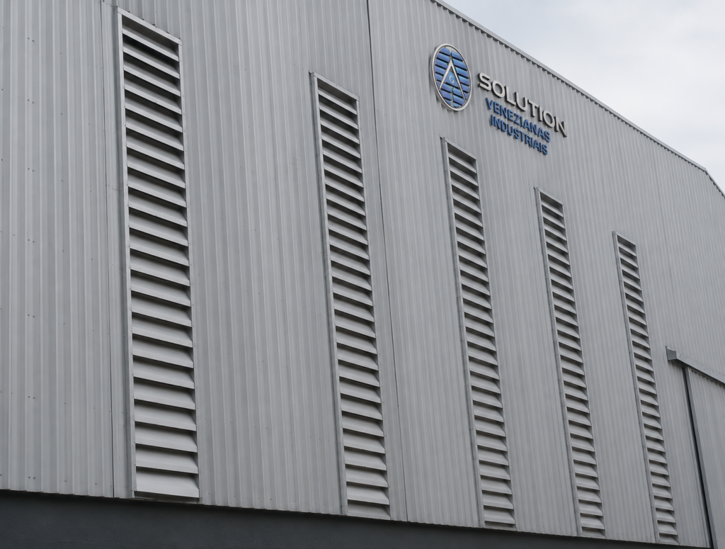 Veneziana Industrial em seu projeto instalada em galpão moderno, oferecendo ventilação natural, conforto térmico e acabamento funcional para ambientes industriais.