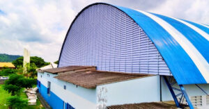 Veneziana Industrial em Policarbonato instalada em galpão industrial, proporcionando ventilação natural, iluminação natural, conforto térmico, alta resistência e excelente durabilidade para ambientes industriais.