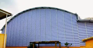 Veneziana para Ginásios instalada em ginásio poliesportivo, proporcionando ventilação natural, iluminação natural, renovação do ar e conforto térmico para ambientes esportivos de grande porte.